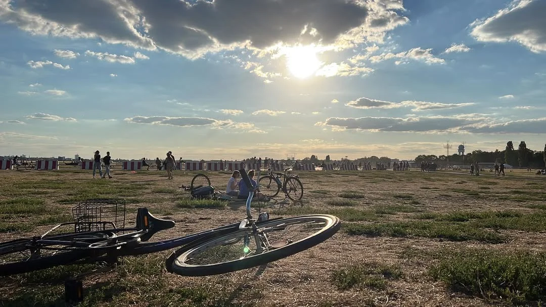 Sonnenuntergang auf dem Tempelhofer Feld in Berlin mit Fahrrädern im Gras